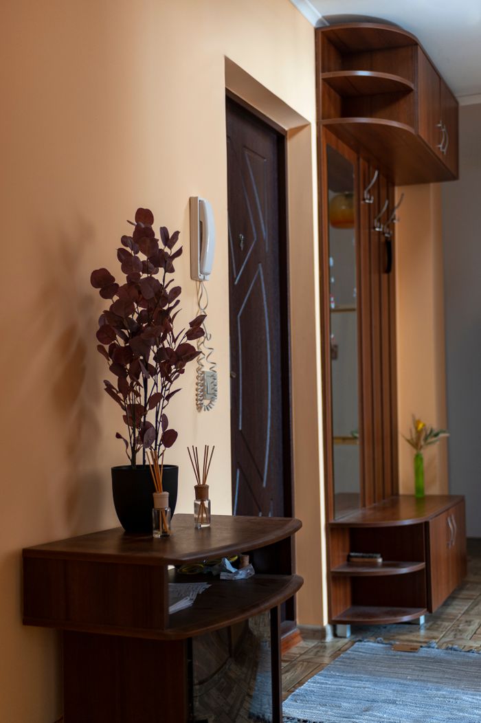 mission-img Modern hallway in a home with wooden furniture and decorative accents.